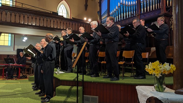 an all mens chorus on a stage performing
