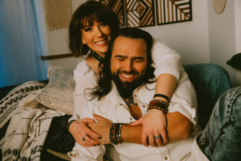Jaaji and Chelsey June sitting on a couch.