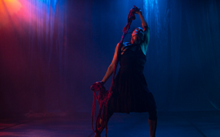 dancer in a black dress, with dark blue background