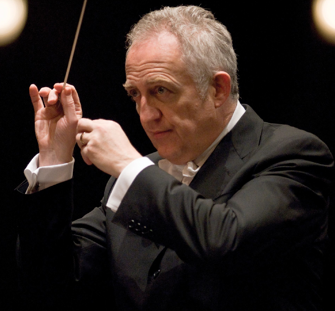 conductor with his hands in front of his face