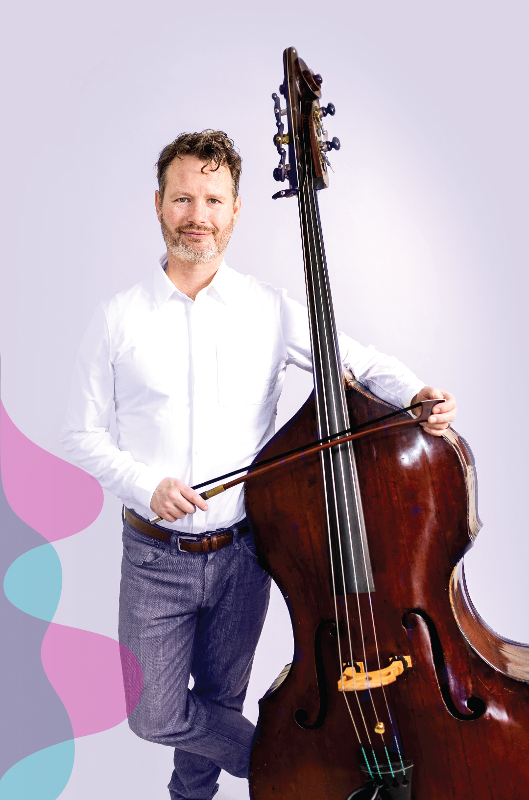 Bass player in a white shirt, standing beside his bass