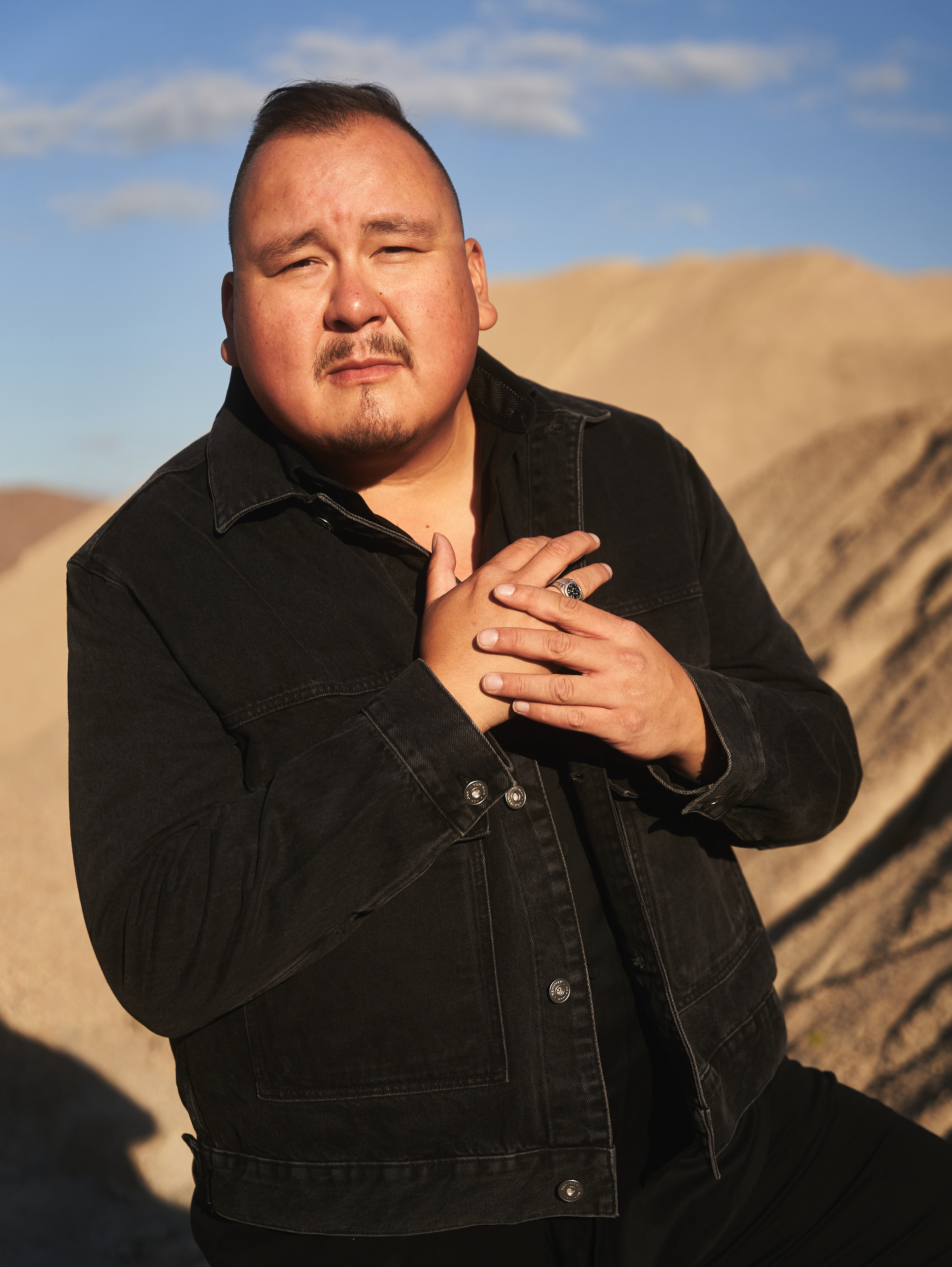 William Prince, performer in a black shirt, hands clasp infront of his chest