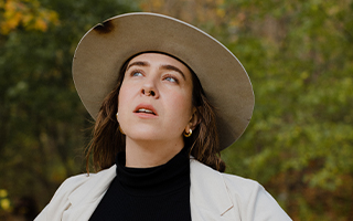 lady in a wide brimmed hat, looking up and to the left