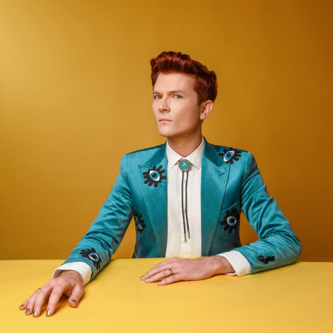 A man with red hair wearing a blue suit