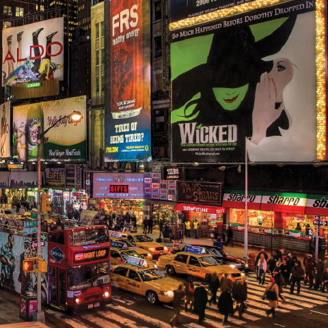Alt text:  Busy Times Square street scene with yellow taxis, a red double-decker bus, and large illuminated theatre billboards.