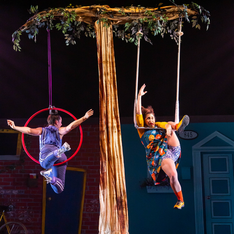 2 actors hanging from ropes on a prop tree