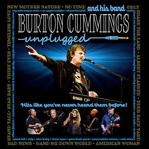 Burton Cummings on stage, singing into a microphone with his arm in the air