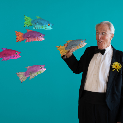 white haired male with in a tuxedo with cartoon fish swimming