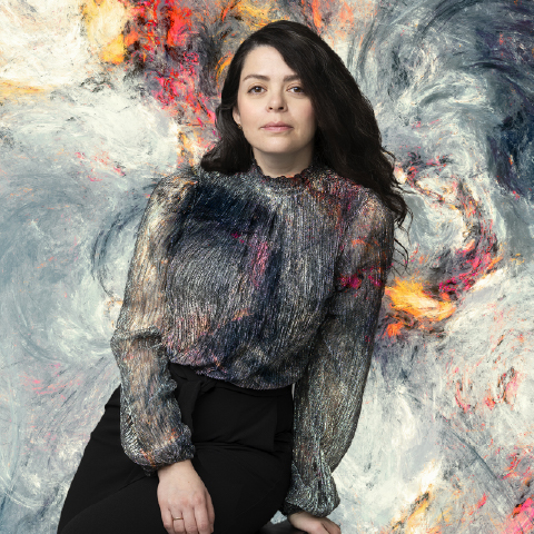 dark haired female in front of a greyed out background