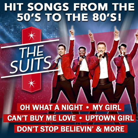 Four men in red suits with their hands in the air.