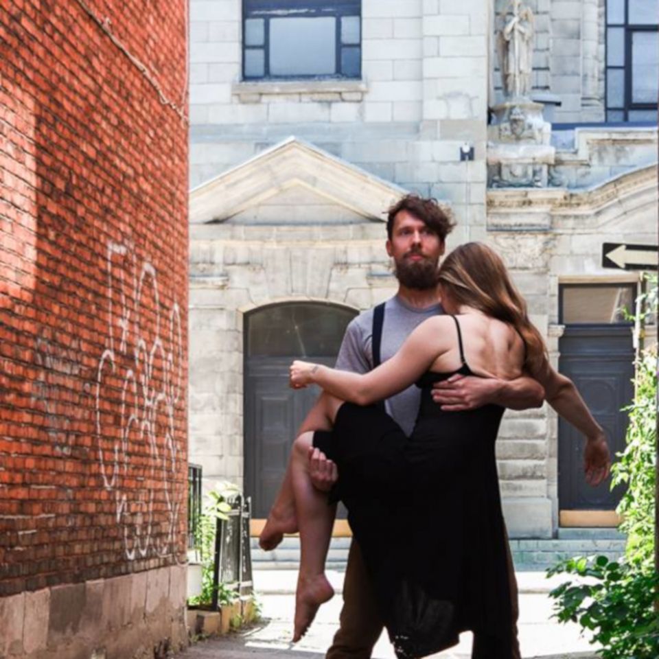 Beneath Your Feet dancer with female dancer in his arms, in a urban alley