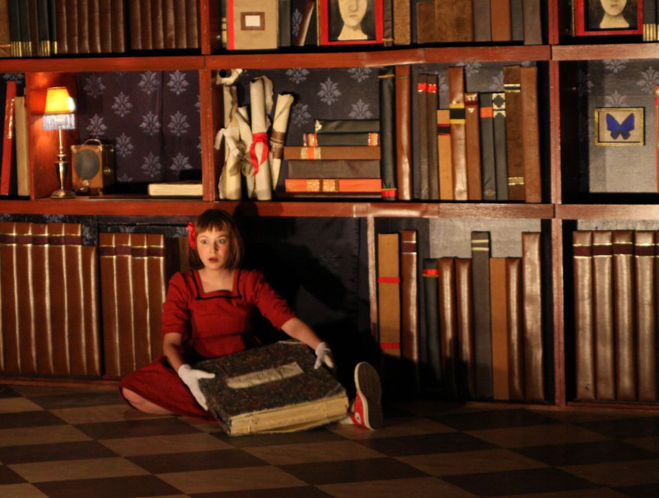 Alice in Wonderland Alice in a library opening a book