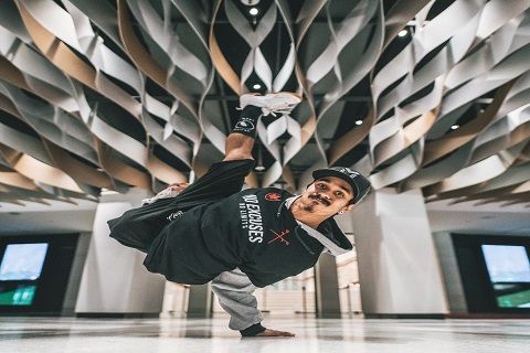 a young man dancing while balancing on one hand
