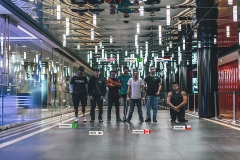 An image of 7 young men wearing urban clothing who perform dance moves