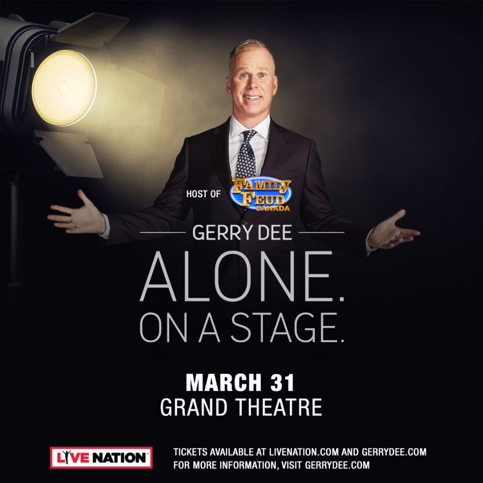 Gerry Dee. Alone. On A Stage. Gerry Dee, hands spread wide on a stage with spotlight in top right corner