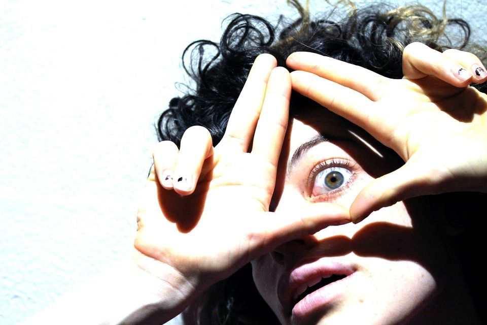 Dance Side of the Moon big green eye looking through fingers creating a triangle