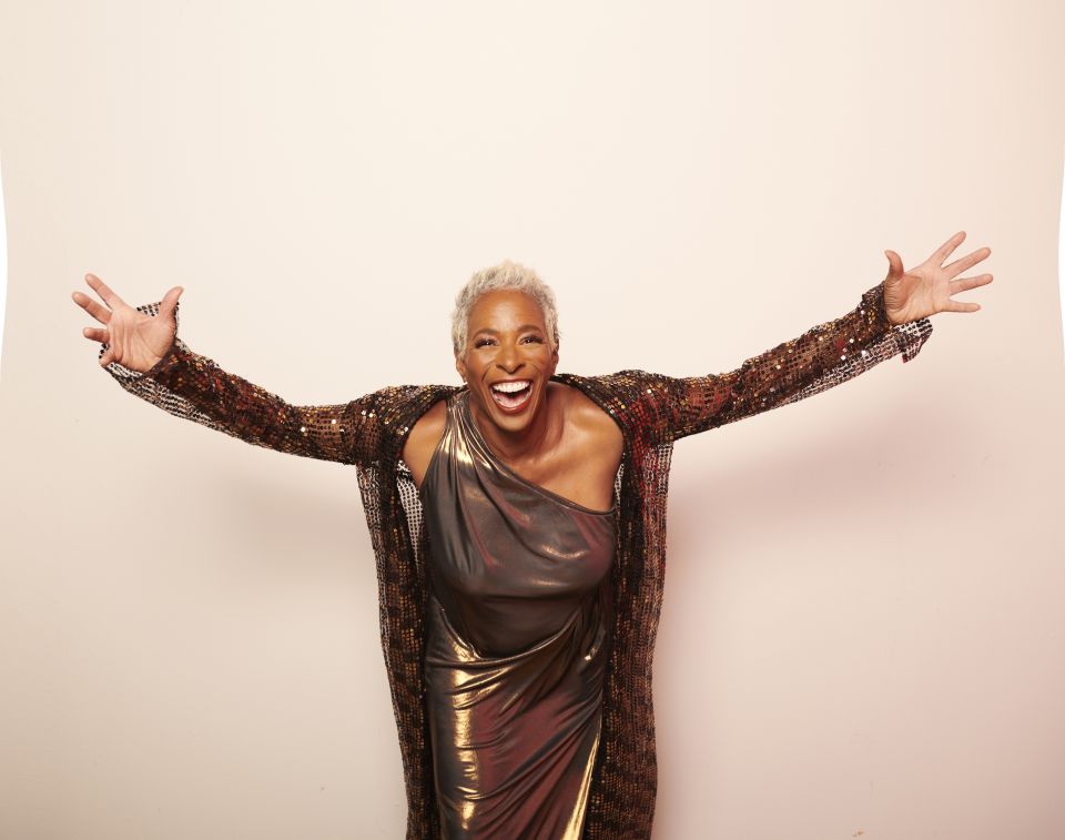 Shakura looking at the camera holding arms in the air