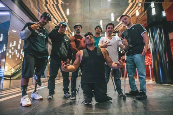 An image of 7 young men wearing urban clothing who perform dance moves
