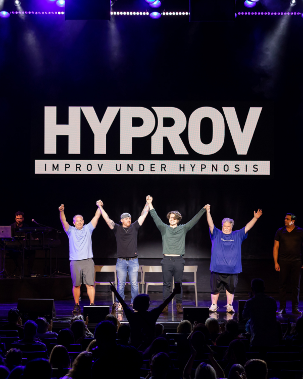 Hyprov word over 4 people on stage raising their hands in the air