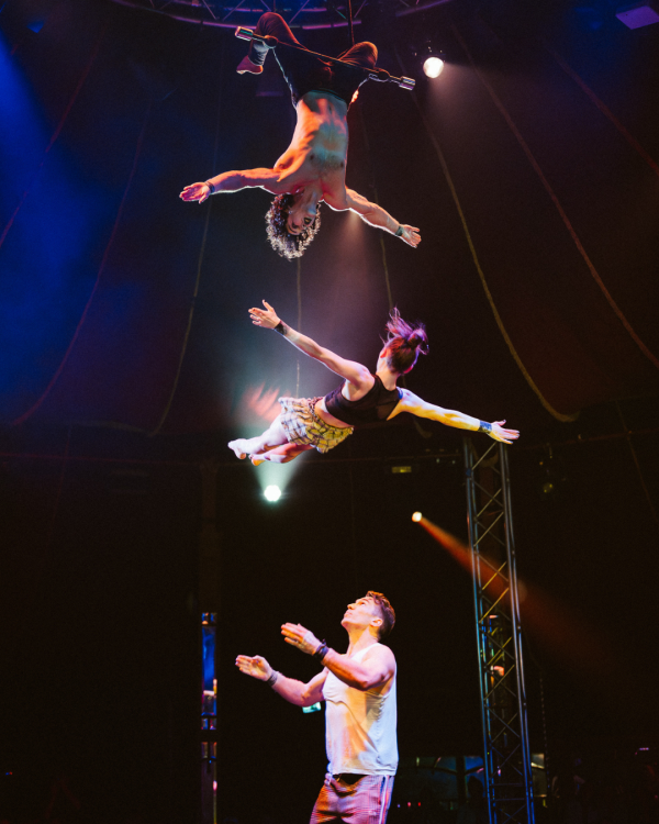 performers in the air, two hanging upside down