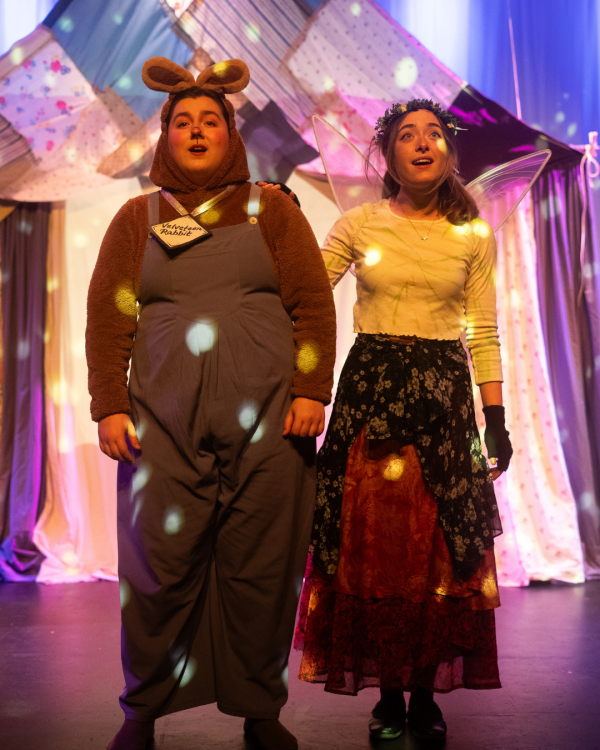 2 actors one in animal ears looking at the camera on stage