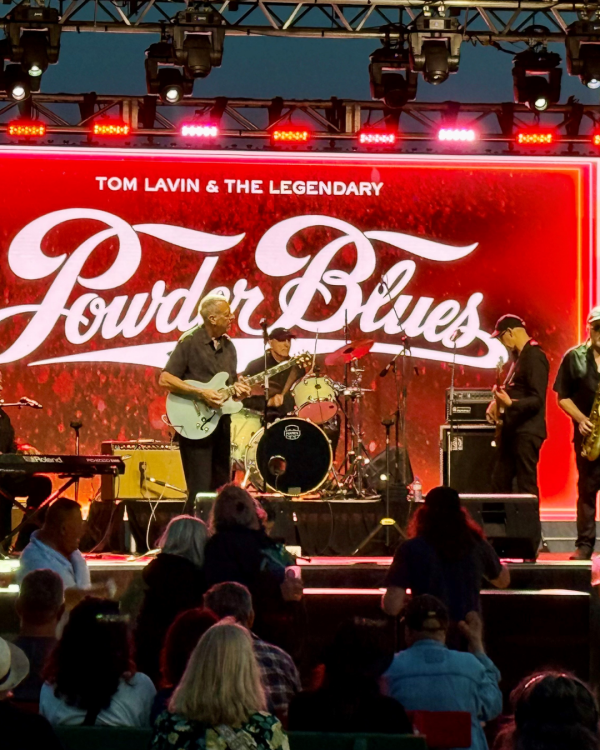 performers with the a Powder Blues sign in the back ground in red