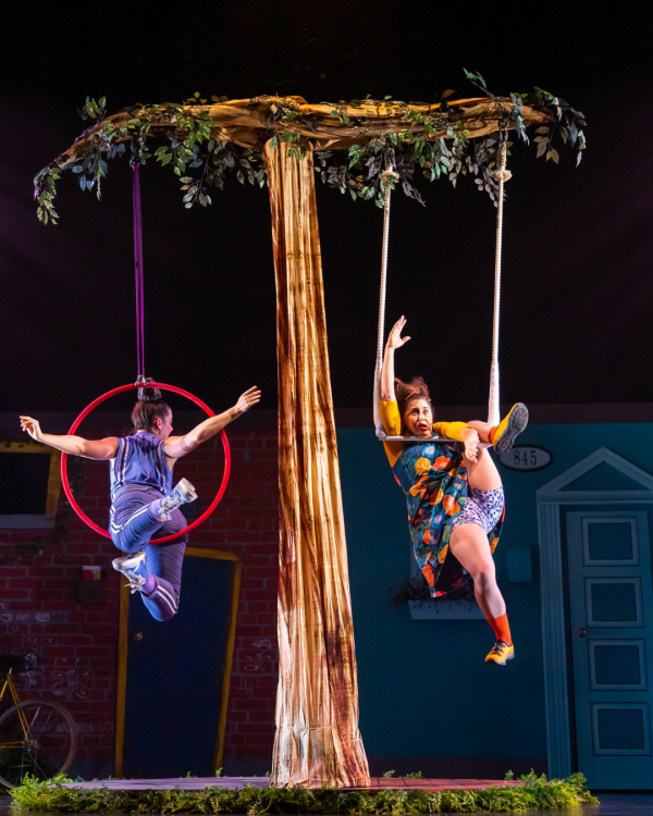 two actors swinging from ropes hanging from a prop tree