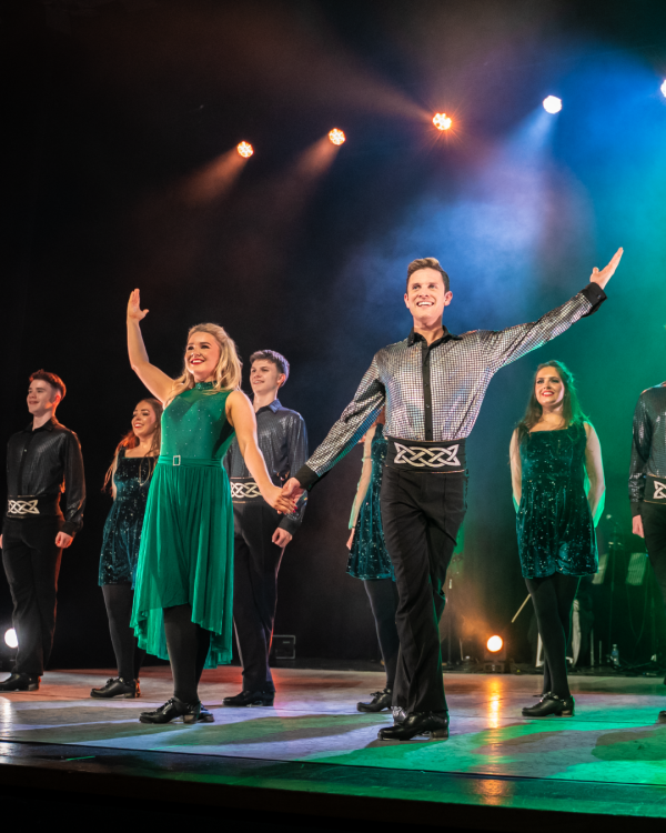 two dancers holding hands dressed in green