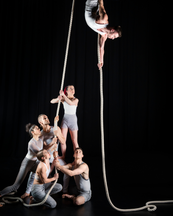 One performer pulled high in the air and three on the ground with another being lifted up