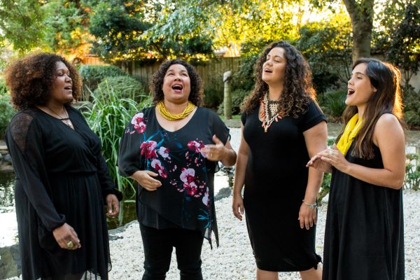 Four women singing outside.