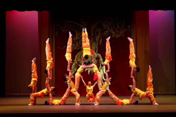 performers doing handstands in a perfect arch on stage