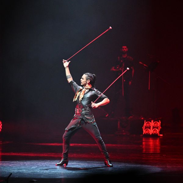 a male dancer alone on stage with arm raised