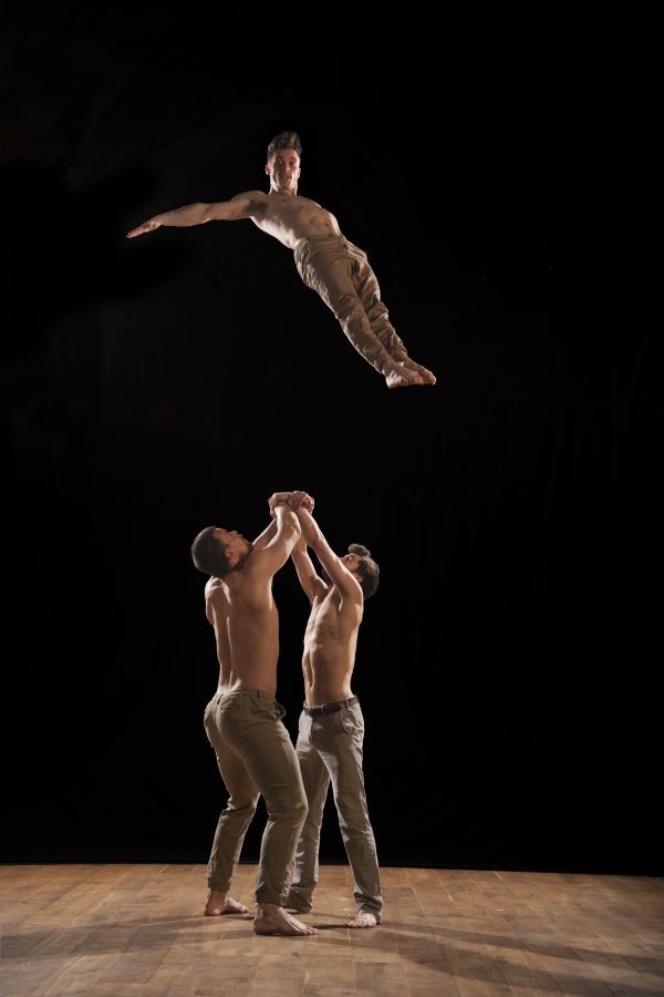Three bare chested men performance acrobatics
