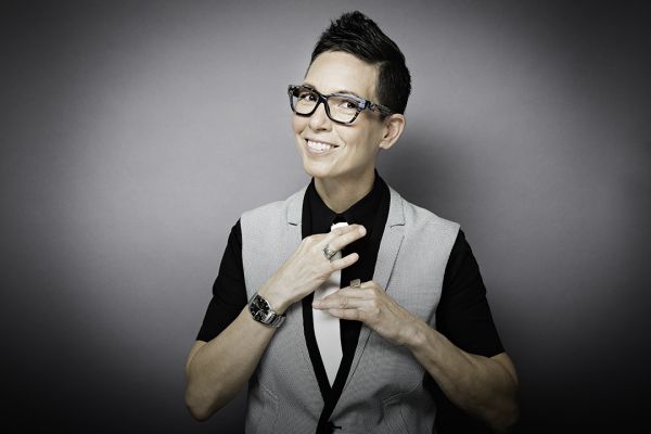 Elvira Kurt dressed in black and grey adjusting a tie