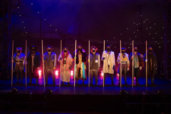 The 7 Fingers Group standing side by side with wooden upright poles between each member