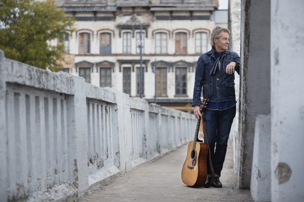 Jim Cuddy leaning against a wall while standing on a ramp