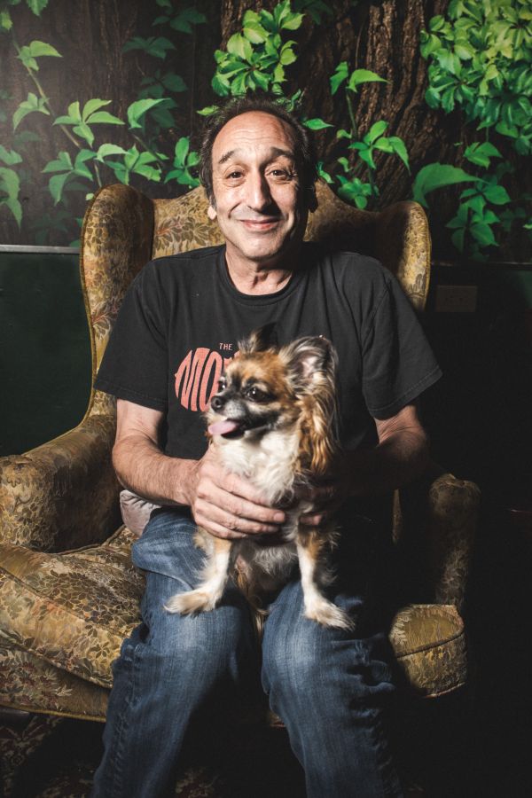 Jeremy Hotz sat in a chair with a small dog
