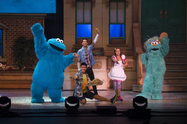 Sesame Street Live! characters dancing on stage.