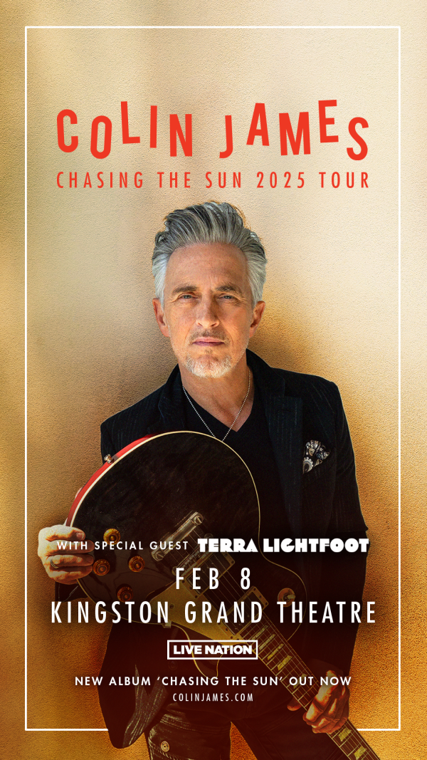greying gentleman standing with a guitar upside down