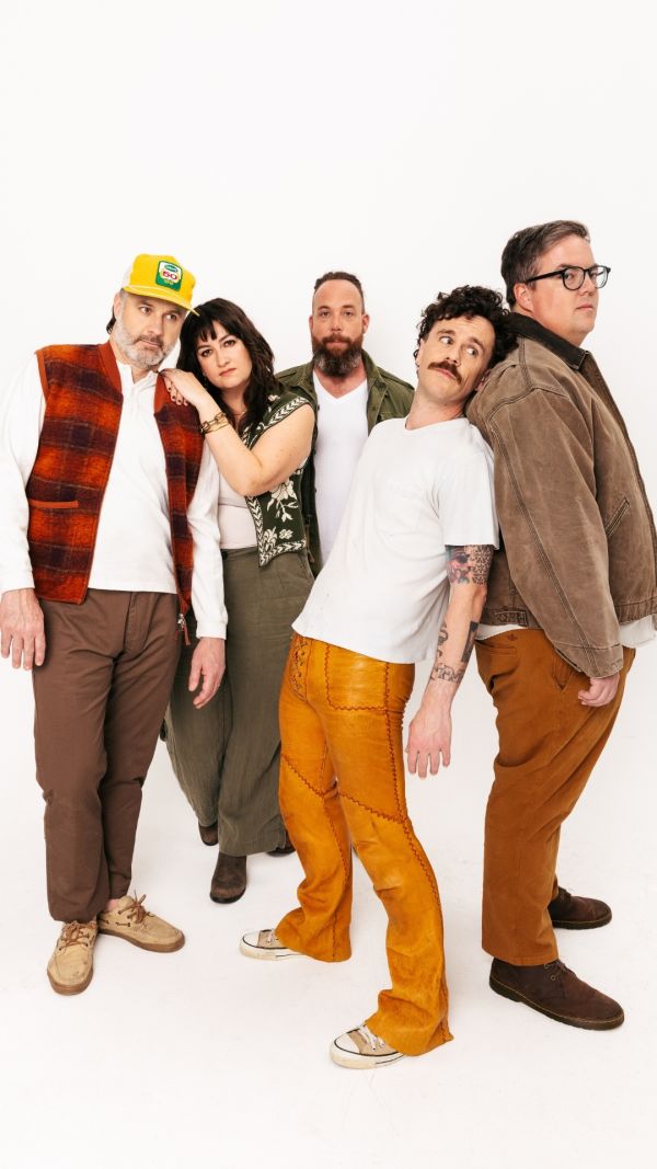 musical group standing in front of a white background