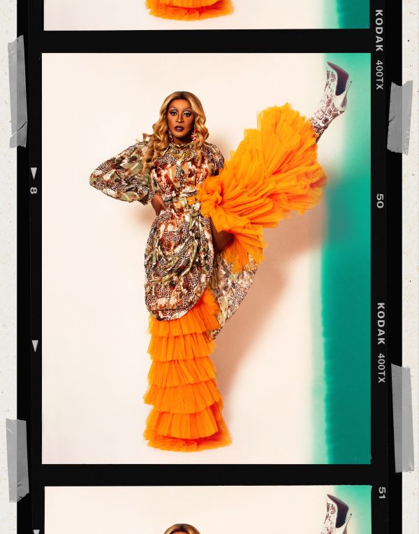 Tynomi Banks by Quinton Cruickshanks drag queen in orange with her foot up in the air