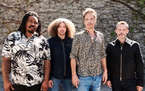 Members of Big Wreck in front of a stone wall